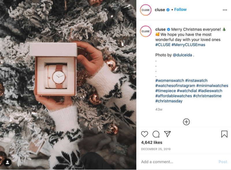 Instagram post od @cluse przedstawiający zdjęcie pokrytej płatkami śniegu modelki trzymającej zegarek przed zaśnieżonym drzewem autorstwa @dulceida z hashtagami #cluse i #meryclusemas