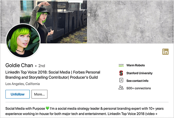 To jest zrzut ekranu profilu Goldie Chan na LinkedIn. Jest Azjatką o zielonych włosach. Na swoim zdjęciu profilowym ma na sobie makijaż, czarny naszyjnik choker i czarną koszulę. Jej slogan brzmi: „LinkedIn Top Voice 2018: Social Media | Forbes Personal Branding and Storytelling Contributor | Gildia producentów ”