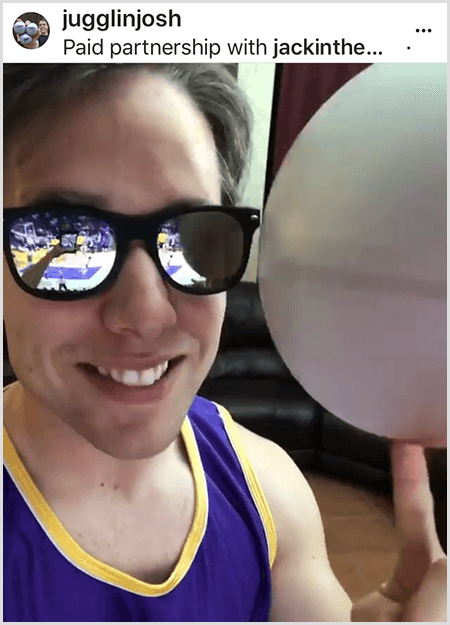 Josh Horton publikuje zdjęcie do kampanii z Jack in the Box i LA Lakers. Josh nosi lustrzane okulary przeciwsłoneczne i koszulkę Lakers i uśmiecha się do kamery, kręcąc piłką.